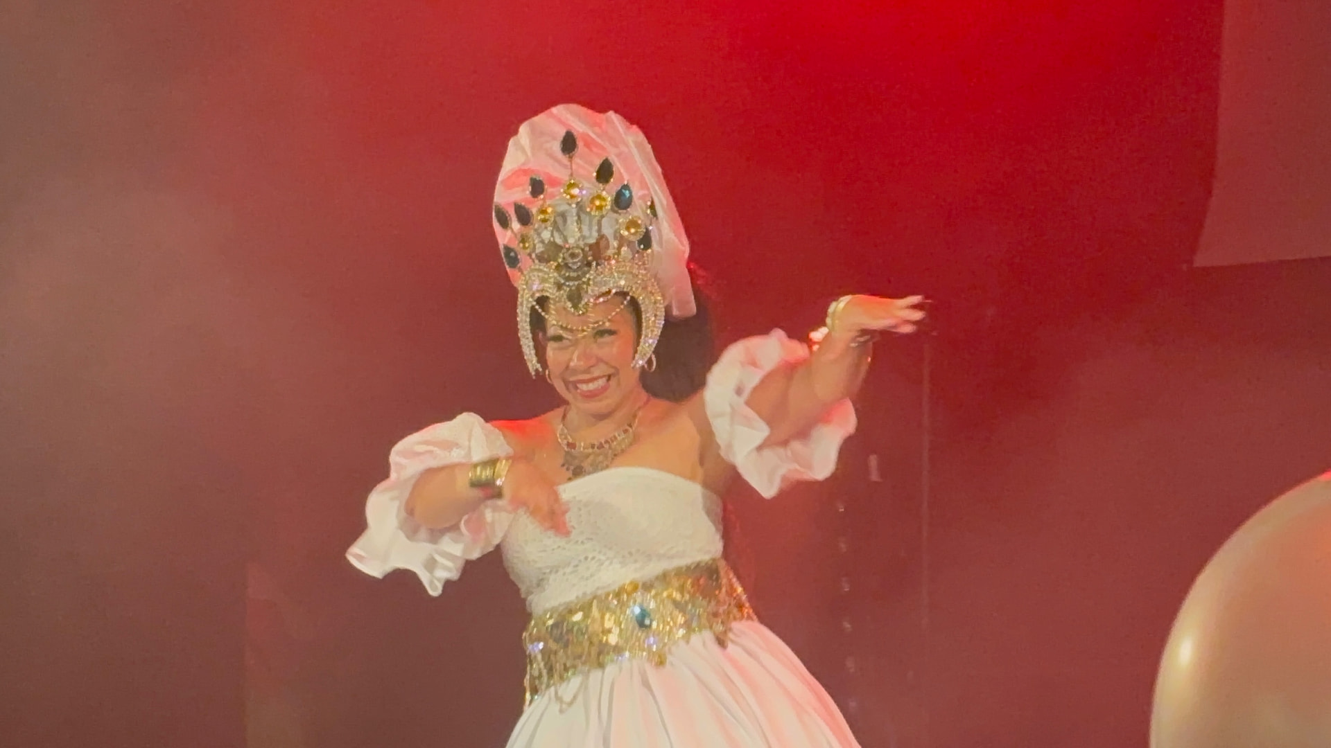 A dancer in ornate cultural costume performing at a Zesti movement workshop